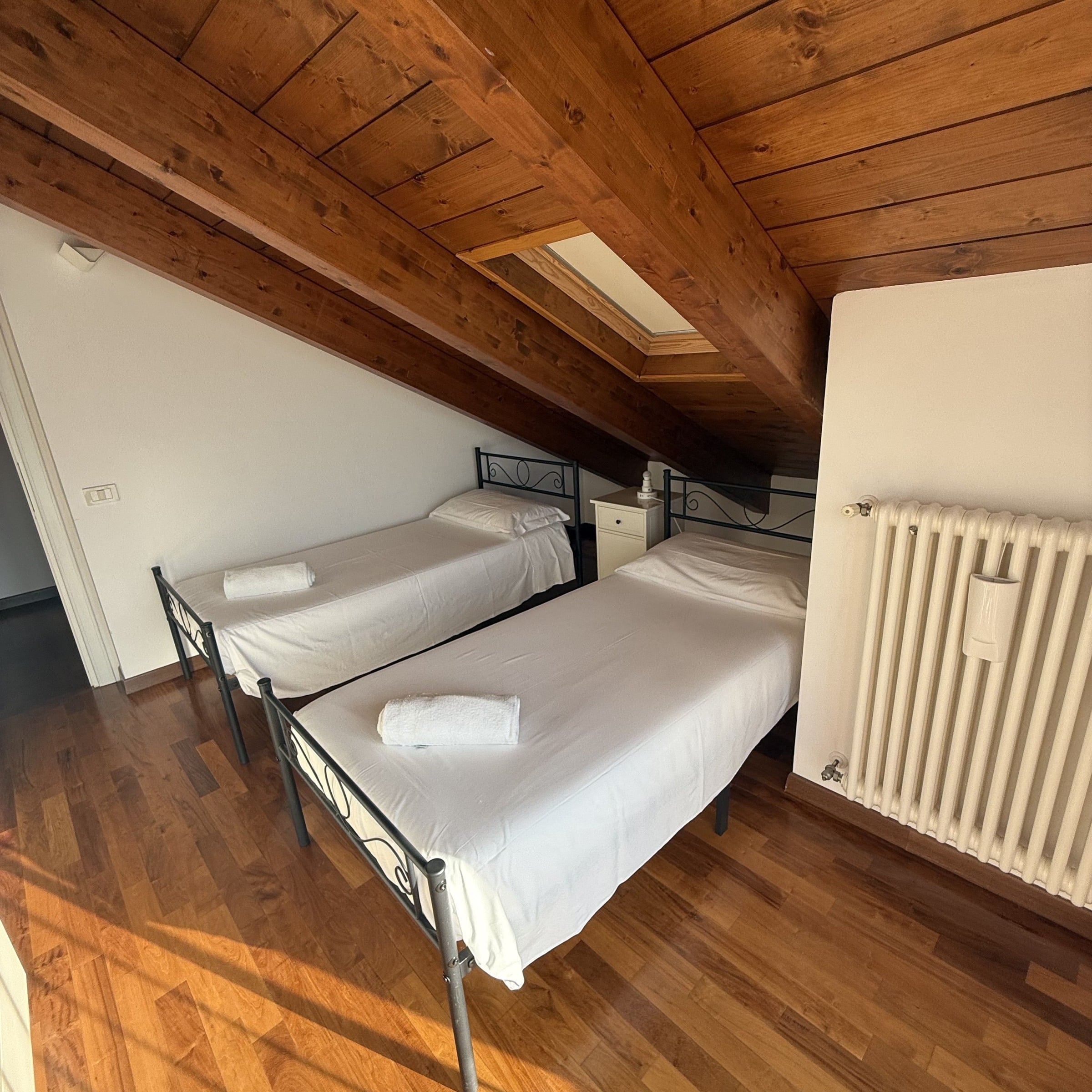 Twin bedroom with two single beds beneath exposed timber beams