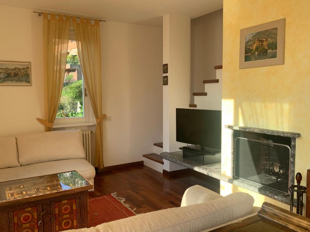 Living room seating area with television, fireplace and internal staircase